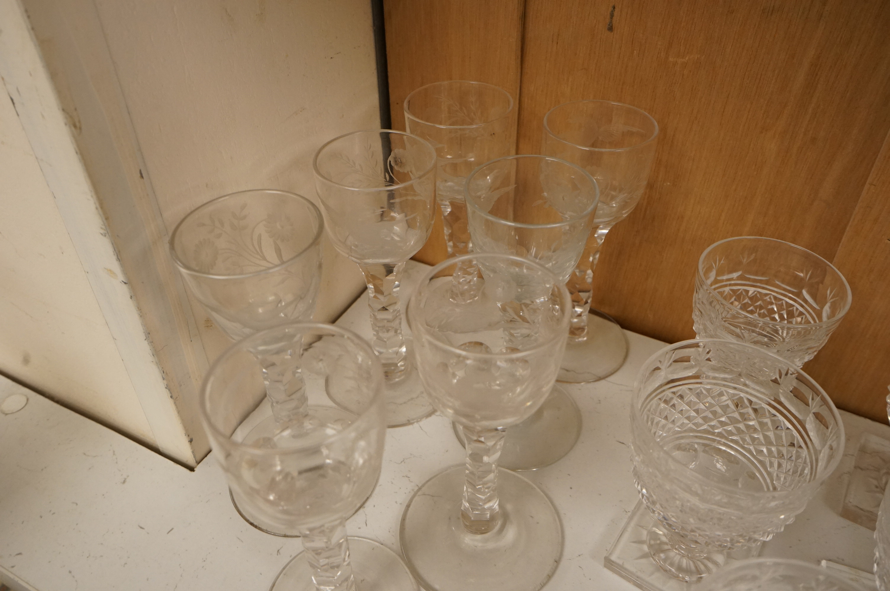 Seven Georgian style facet stem engraved wine glasses and a part suite of 19th centuy rummers, largest 14cm high